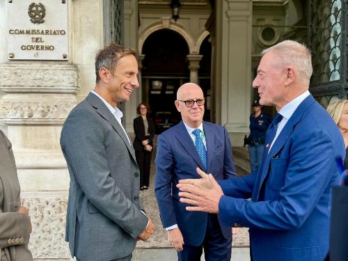 Il governatore Fedriga saluta il ministro Urso al suo arrivo. Al centro il prefetto di Trieste Giuseppe Petronzi