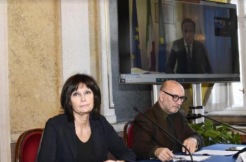 In primo piano l'assessore al Lavoro Alessia Rosolen e il giornalista dell'Ansa Francesco De Filippo. Sullo schermo il governatore Massimiliano Fedriga