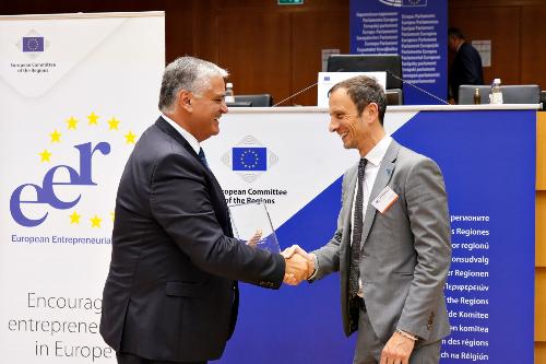 Il governatore Massimiliano Fedriga mentre riceve dal presidente del Comitato europeo delle Regioni Vasco Cordeiro il premio EER 2024