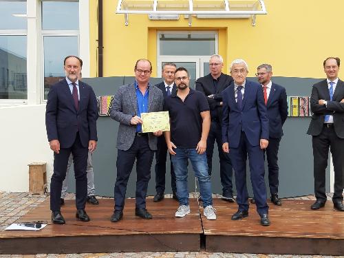 Il vicegovernatore Mario Anzil premia uno degli studenti della scuola mosaicisti di Spilimbergo