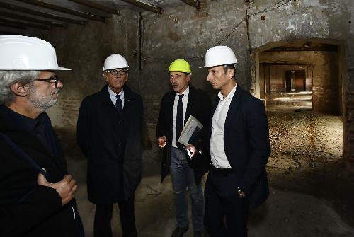 Il governatore Massimiliano Fedriga (primo a destra) in Porto Vecchio durante il sopralluogo nei magazzini destinati a ospitare i nuovi uffici della Regione