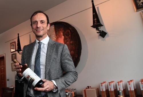 Il governatore della Regione Massimiliano Fedriga con in mano una delle bottiglie del Vino della solidarietà