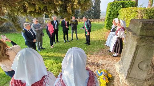 Un momento della cerimonia nel parco della chiesa di Sant'Eufemia a Segnacco di Tarcento innanzi il cippo a memoria di Chino Ermacora 