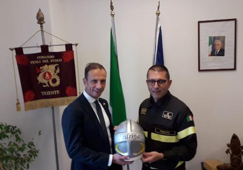 Il comandante Maiolo consegna al governatore Fedriga un casco speciale. 