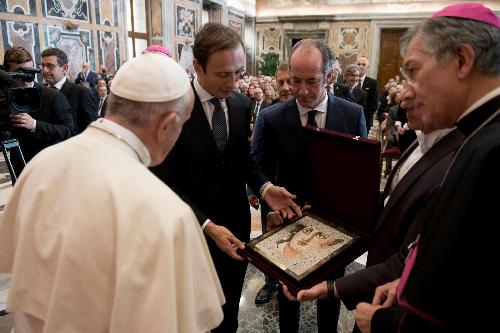 Il momento in cui il governatore della Regione, Massimiliano Fedriga, ha donato al Papa alcuni oggetti del nostro territorio, tra cui un mosaico realizzato dalla scuola di Spilimbergo, che raffigura un bassorilievo presente ad Aquileia.