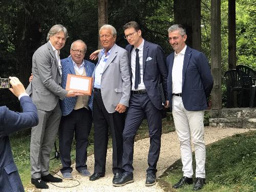 L'assessore regionale Sergio Emidio Bini insieme al presidente di Unindustria Pordenone Michelangelo Agrusti consegnano un riconoscimento al titolare dell'azienda Ausonia di Maniago