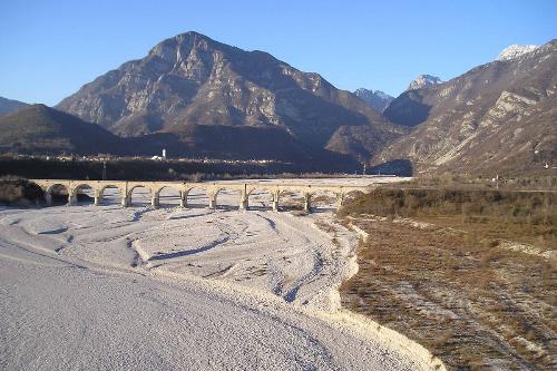 Il greto del Torrente Cellina, il Ponte della Ferrovia e l'abitato di Montereale Valcellina (Pordenone) sovrastato dal Monte Fara