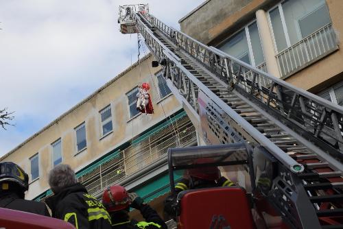 Il vigile del fuoco-San Nicolò issato con un'autoscala sulla terrazza del reparto di oncoematologia del Burlo di Trieste