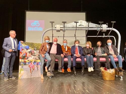 Foto di grupo sul palco del teatro di Tolmezzo dei rappresentanti della giunta regionale insieme al campione di ciclismo Gilberto Simoni