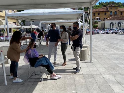 L'assessore Roberti mentre le parrucchiere tagliano i capelli ai giovani volontari