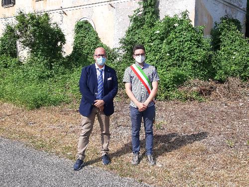 L'assessore regionale al Demanio, Sebastiano Callari, con il sindaco di Dogna, Simone Peruzzi, davanti alla vecchia stazione ferroviaria ceduta al Comune