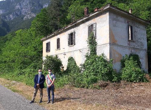 L'assessore regionale al Demanio, Sebastiano Callari, con il sindaco di Dogna, Simone Peruzzi, davanti alla vecchia stazione ferroviaria ceduta al Comune