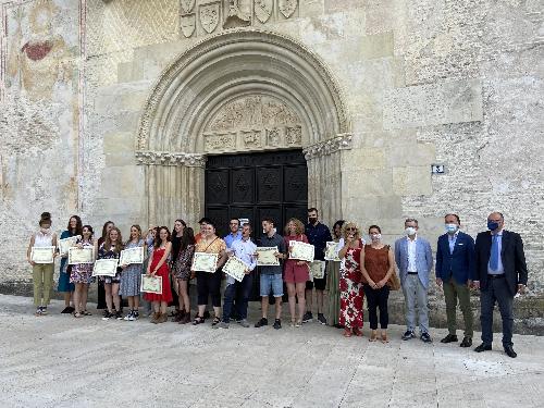 Foto di gruppo degli studenti diplomati alla Scuola mosaicisti del Friuli, alla presenza dell'assessore regionale Stefan Zannier fuori dal Duomo di Spilimbergo
