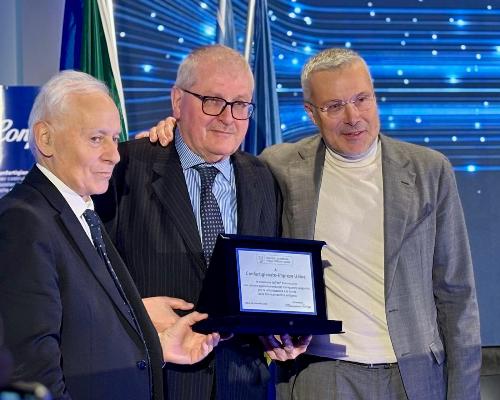 La consegna da parte dell'assessore regionale Sergio Emidio Bini della targa a Tiziano Tilatti (al centro)