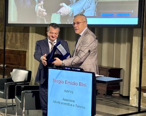 L'assessore regionale alle Attività produttive e Turismo, Sergio Emidio Bini consegna a nome del governatore Massimiliano Fedriga una targa commemorativa al presidente di Aster Coop Claudio Macorig
